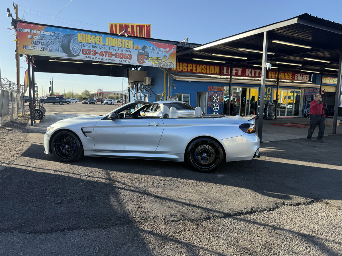 BMW convertible with custom wheels in front of Wheel Master shop